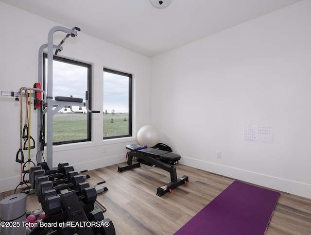 workout room with baseboards and wood finished floors