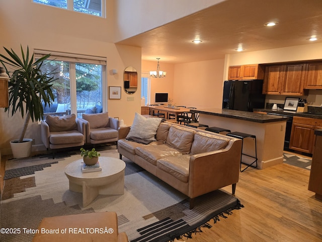 living room with light wood-style floors, an inviting chandelier, and recessed lighting