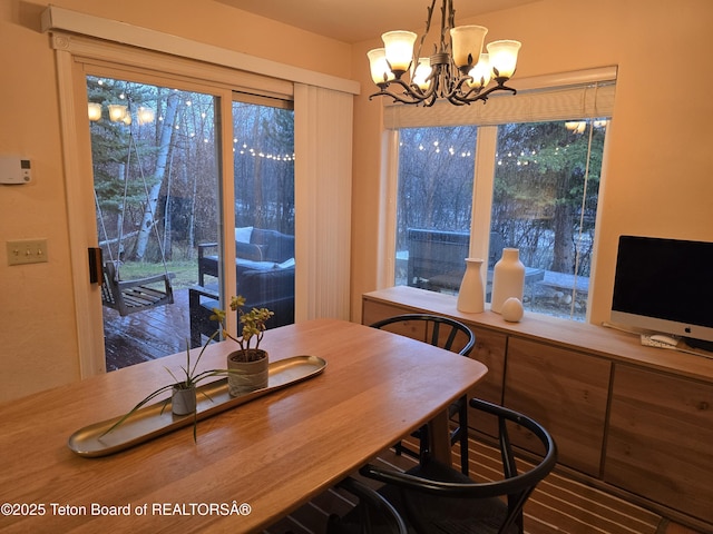 dining area featuring a wealth of natural light and a notable chandelier