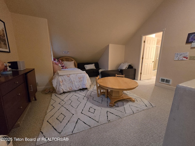 carpeted bedroom featuring connected bathroom, visible vents, and lofted ceiling