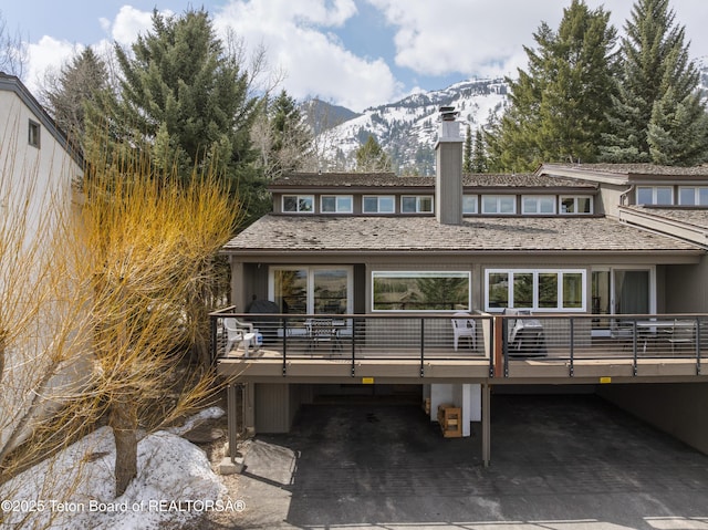 7250 N Rachel Way Unit 6, Teton Village, WY 83025 - back of house with a chimney and a deck with mountain view