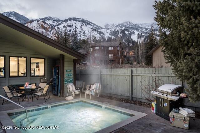 7250 N Rachel Way Unit 6, Teton Village, WY 83025 - community pool with a mountain view, fence, area for grilling, and a patio area