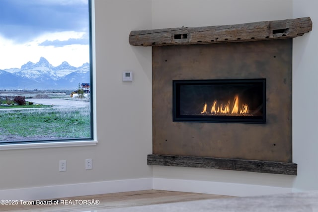 4444 Tails Down Rd, Tetonia, ID 83452 - detailed view of a mountain view, baseboards, a lit fireplace, and wood finished floors