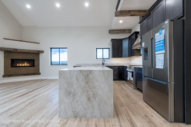 4444 Tails Down Rd, Tetonia, ID 83452 - kitchen featuring appliances with stainless steel finishes, wall chimney range hood, light wood-style floors, a kitchen island, and recessed lighting
