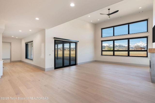 1404 Canyon Sunrise, Driggs, ID 83422 - spare room featuring light wood-style floors, healthy amount of natural light, recessed lighting, baseboards, and a towering ceiling
