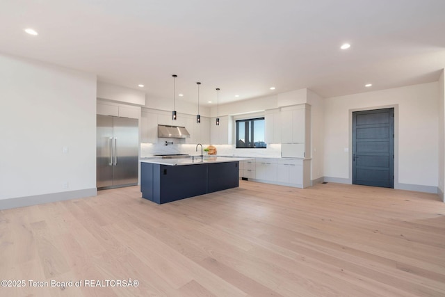 1404 Canyon Sunrise, Driggs, ID 83422 - kitchen with stainless steel built in refrigerator, under cabinet range hood, a kitchen island with sink, light countertops, and recessed lighting