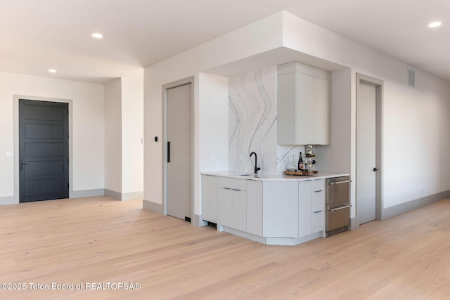 1404 Canyon Sunrise, Driggs, ID 83422 - bar area with light wood finished floors, recessed lighting, a sink, baseboards, and decorative backsplash