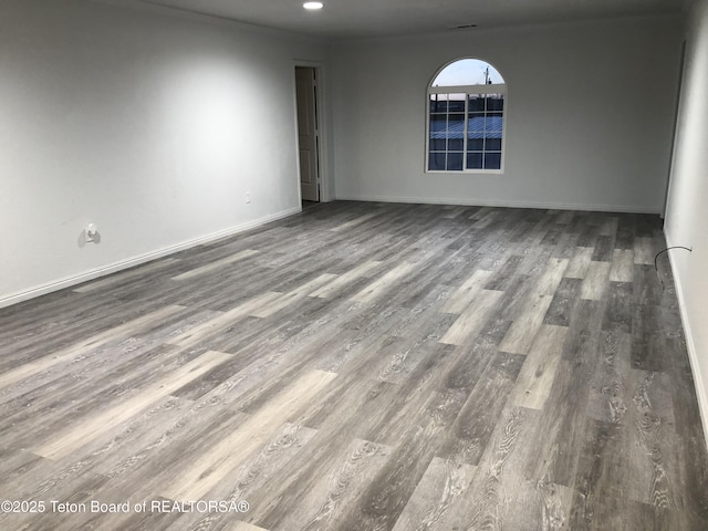 spare room featuring wood finished floors, baseboards, and recessed lighting