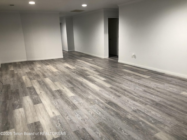 empty room with wood finished floors, baseboards, and recessed lighting