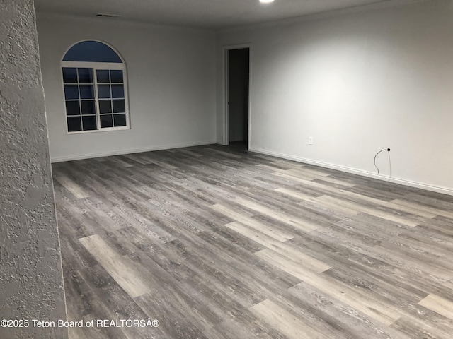 spare room with wood finished floors and baseboards