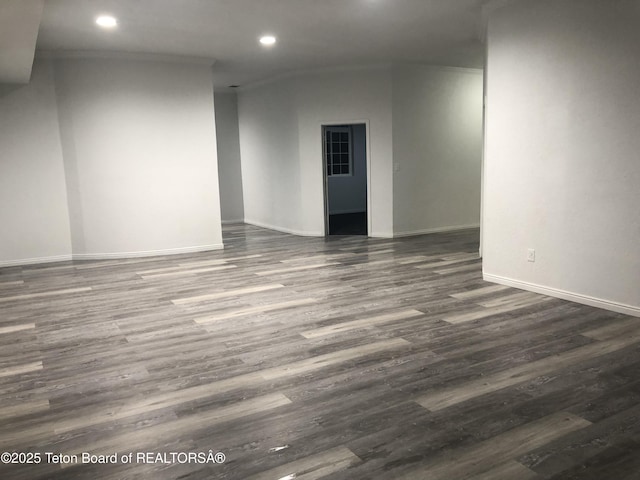 spare room featuring dark wood-style flooring, ornamental molding, baseboards, and recessed lighting