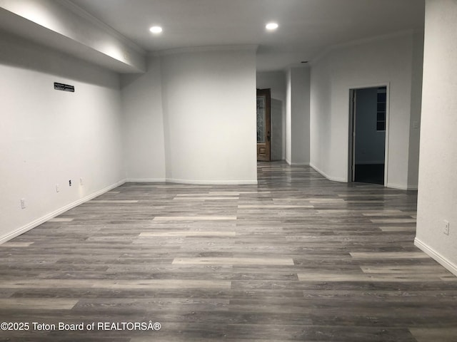 empty room featuring crown molding, wood finished floors, and recessed lighting