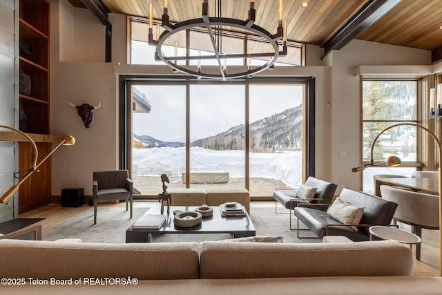 living area featuring a mountain view, wood ceiling, wood finished floors, and lofted ceiling with beams