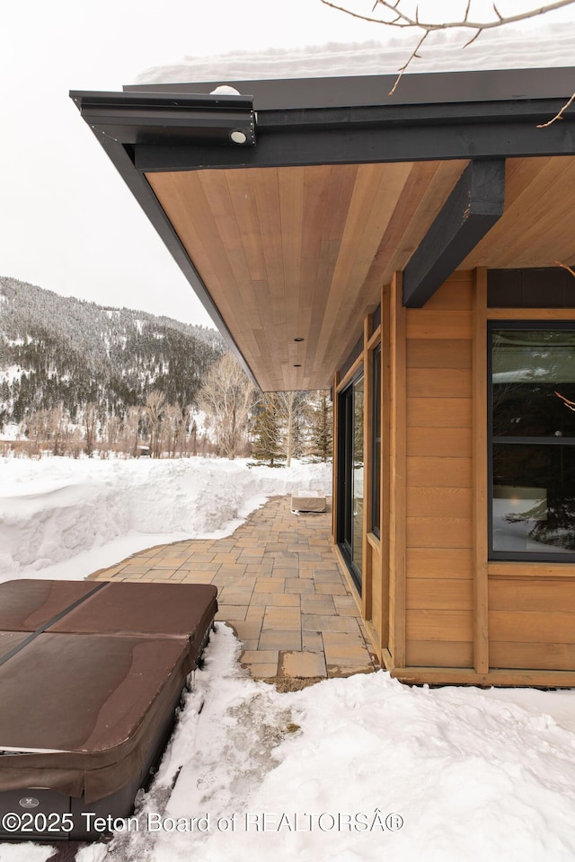 snow covered patio with a mountain view