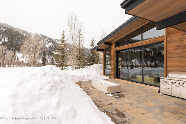 snow covered patio with a mountain view