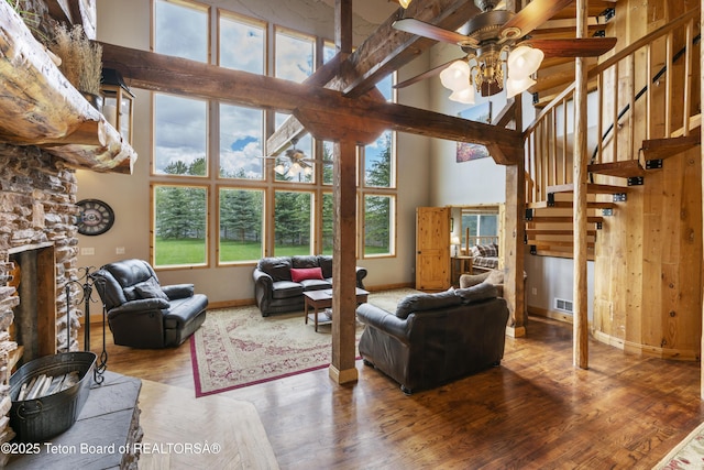 living area featuring ceiling fan, baseboards, high vaulted ceiling, and plenty of natural light