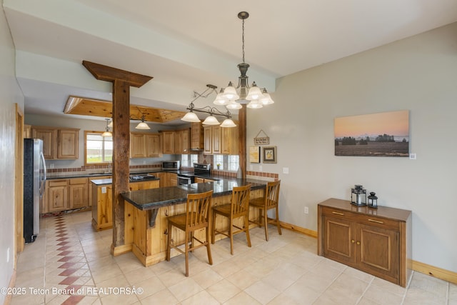 kitchen with a breakfast bar area, baseboards, a peninsula, brown cabinets, and stainless steel appliances
