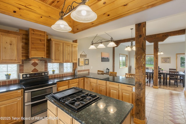 kitchen featuring black gas cooktop, wall chimney exhaust hood, decorative backsplash, double oven range, and a kitchen island