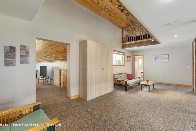 living area featuring carpet flooring, wooden ceiling, baseboards, and high vaulted ceiling