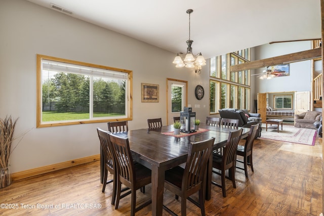 dining room featuring a chandelier, visible vents, wood finished floors, and baseboards