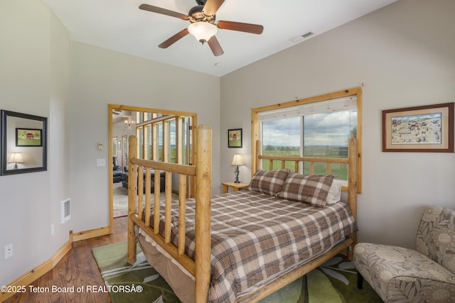 bedroom with baseboards, visible vents, a ceiling fan, and wood finished floors