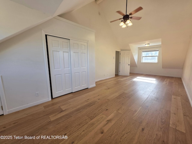bonus room featuring light wood-style flooring, baseboards, ceiling fan, and high vaulted ceiling