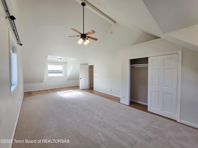 interior space featuring high vaulted ceiling, beamed ceiling, baseboards, and a ceiling fan