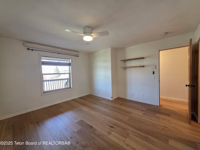 spare room featuring baseboards, a ceiling fan, and wood finished floors