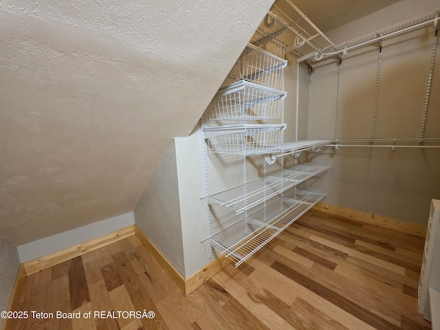 spacious closet with wood finished floors and lofted ceiling