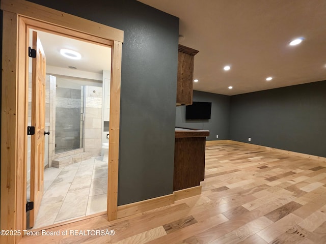 interior space featuring baseboards, light wood finished floors, and recessed lighting