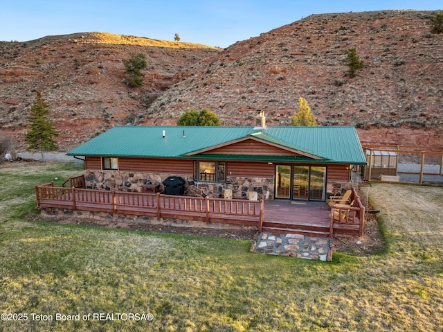 9 Warm Springs Rd, Dubois, WY 82513 - rear view of property featuring a yard, a deck with mountain view, faux log siding, and metal roof