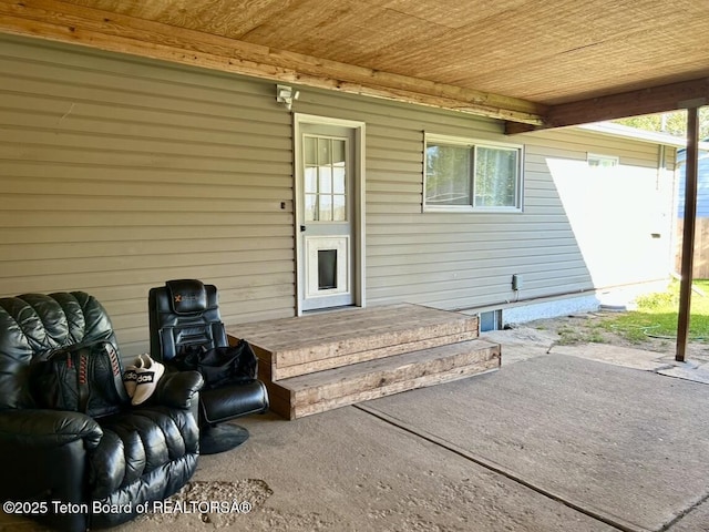 view of exterior entry featuring a patio and crawl space