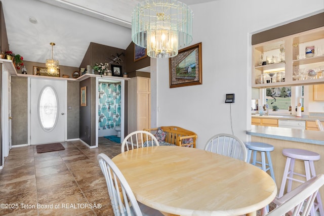 dining area featuring a chandelier, healthy amount of natural light, and vaulted ceiling