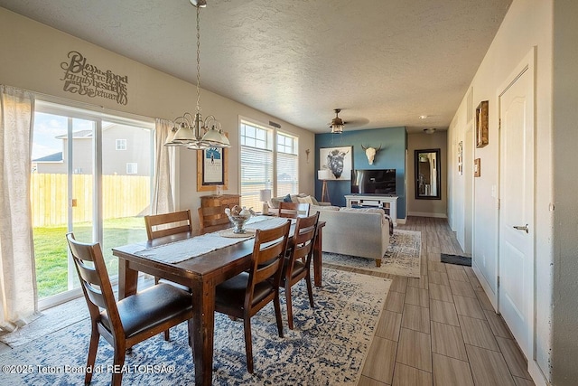 350 Little Greys Loop, Etna, WY 83118 - dining space with a textured ceiling, a chandelier, wood finish floors, and baseboards