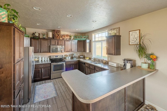 350 Little Greys Loop, Etna, WY 83118 - kitchen with stainless steel appliances, a peninsula, a sink, recessed lighting, and a textured ceiling