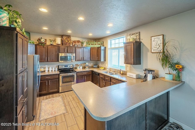 350 Little Greys Loop, Etna, WY 83118 - kitchen featuring stainless steel appliances, recessed lighting, a peninsula, a textured ceiling, and a sink