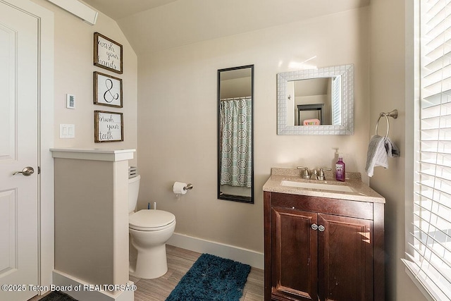 350 Little Greys Loop, Etna, WY 83118 - bathroom featuring toilet, vanity, wood finished floors, baseboards, and vaulted ceiling