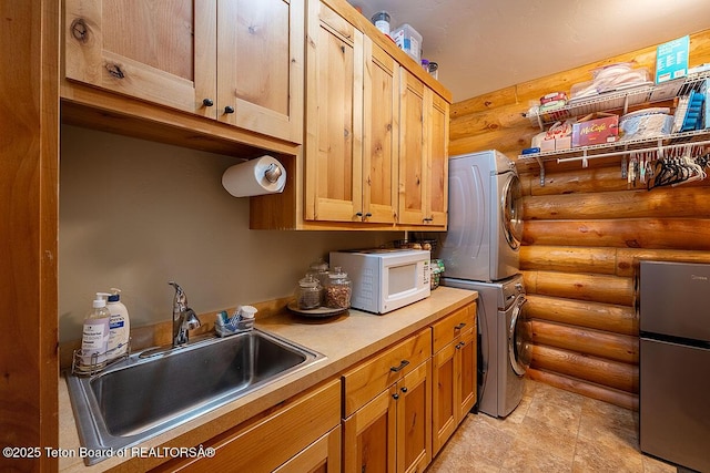 109 Redwood Rd, Star Valley Ranch, WY 83127 - clothes washing area featuring rustic walls, stacked washing machine and dryer, and cabinet space