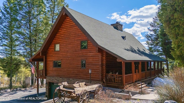 109 Redwood Rd, Star Valley Ranch, WY 83127 - view of side of home featuring a chimney, log exterior, a shingled roof, and an attached garage