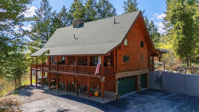 109 Redwood Rd, Star Valley Ranch, WY 83127 - rear view of property with log siding, driveway, a shingled roof, a chimney, and an attached garage