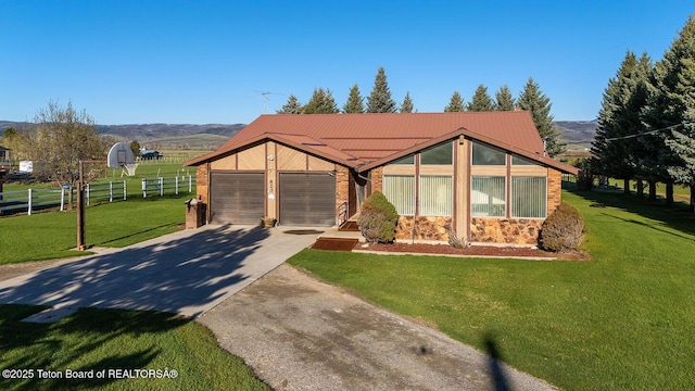 823 Allred Rd, Afton, WY 83110 - view of front of home featuring stone siding, concrete driveway, a garage, metal roof, and a mountain view