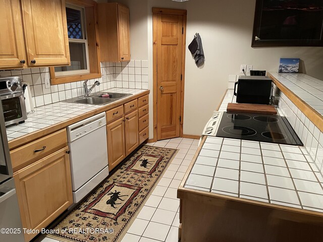 51 Cheyenne Cir, Star Valley Ranch, WY 83127 - kitchen with tile counters, white dishwasher, a sink, decorative backsplash, and light tile patterned floors