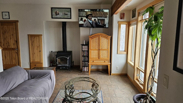 2435 Steelhead Dr, Tetonia, ID 83452 - living room with stone tile floors, baseboards, and a wood stove