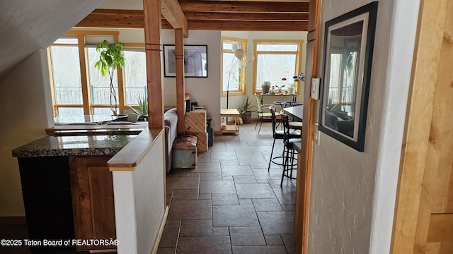 2435 Steelhead Dr, Tetonia, ID 83452 - kitchen with stone tile flooring, plenty of natural light, baseboards, a peninsula, and beam ceiling