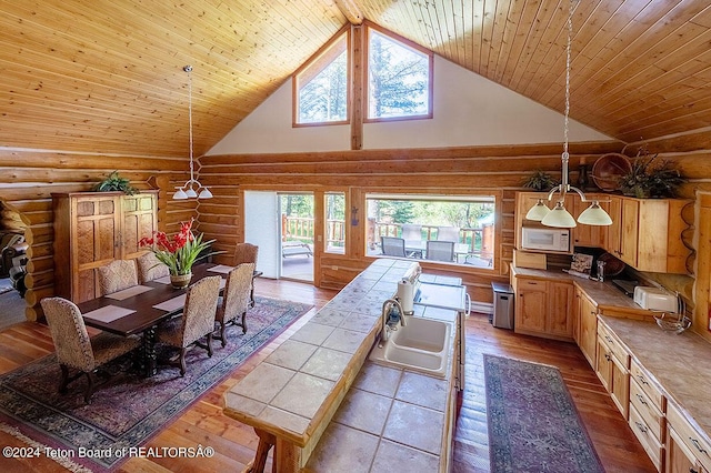 1238 Vista Dr, Star Valley Ranch, WY 83127 - kitchen featuring rustic walls, white microwave, high vaulted ceiling, hardwood / wood-style flooring, and a sink