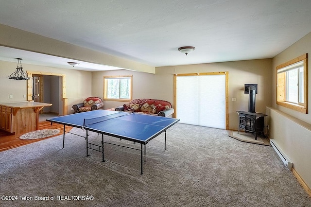 1238 Vista Dr, Star Valley Ranch, WY 83127 - rec room with baseboard heating, carpet floors, a wood stove, and baseboards
