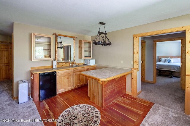 1238 Vista Dr, Star Valley Ranch, WY 83127 - kitchen featuring refrigerator, white microwave, decorative light fixtures, dark wood-style flooring, and baseboards