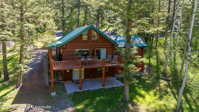 1238 Vista Dr, Star Valley Ranch, WY 83127 - rear view of house featuring log exterior, a patio, a wooden deck, a lawn, and a wooded view