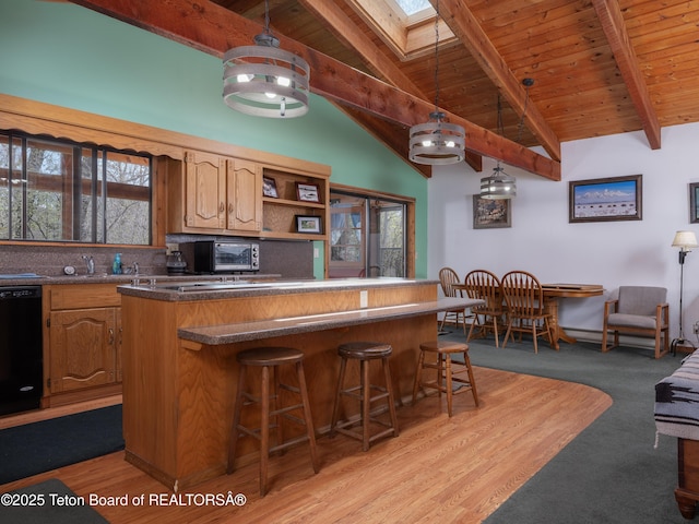 529 Quaking Aspen Dr, Driggs, ID 83422 - kitchen featuring black dishwasher, a kitchen bar, a skylight, backsplash, and open shelves