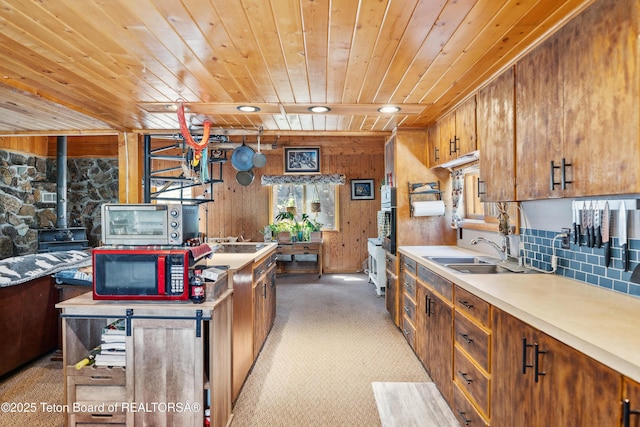2 Porcupine Cir, Dubois, WY 82513 - kitchen with wooden ceiling, a wood stove, plenty of natural light, brown cabinets, and wood walls